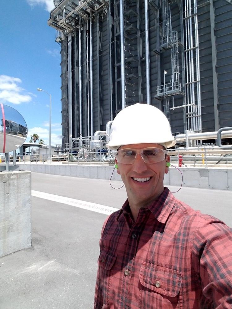 Jeffrey in a hard hat at a large power generation plant